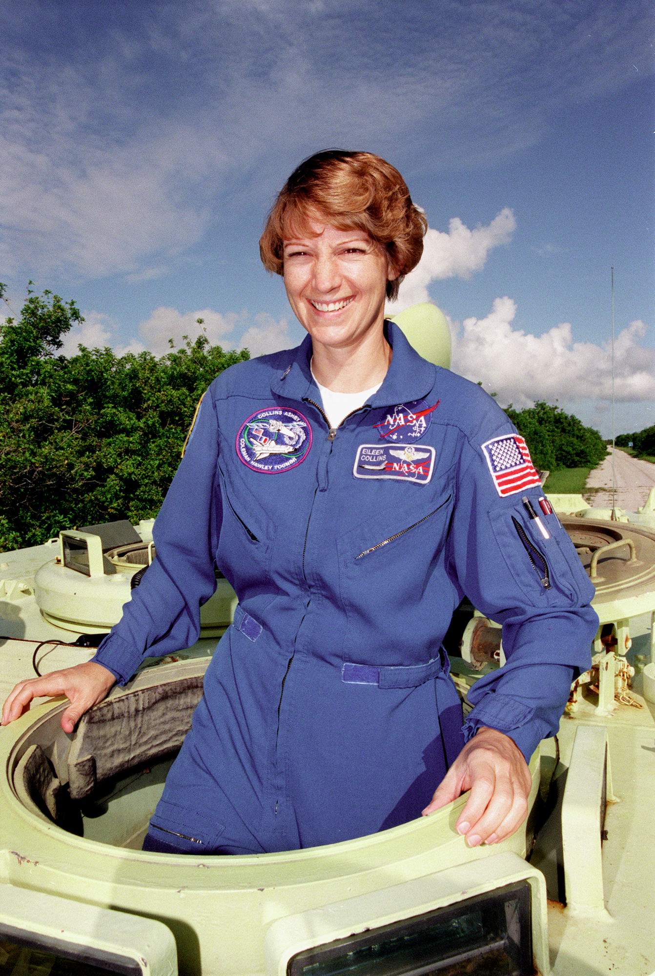 Eileen Collins climbing into an M113 armored personnel carrier as practice for STS-93.jpg