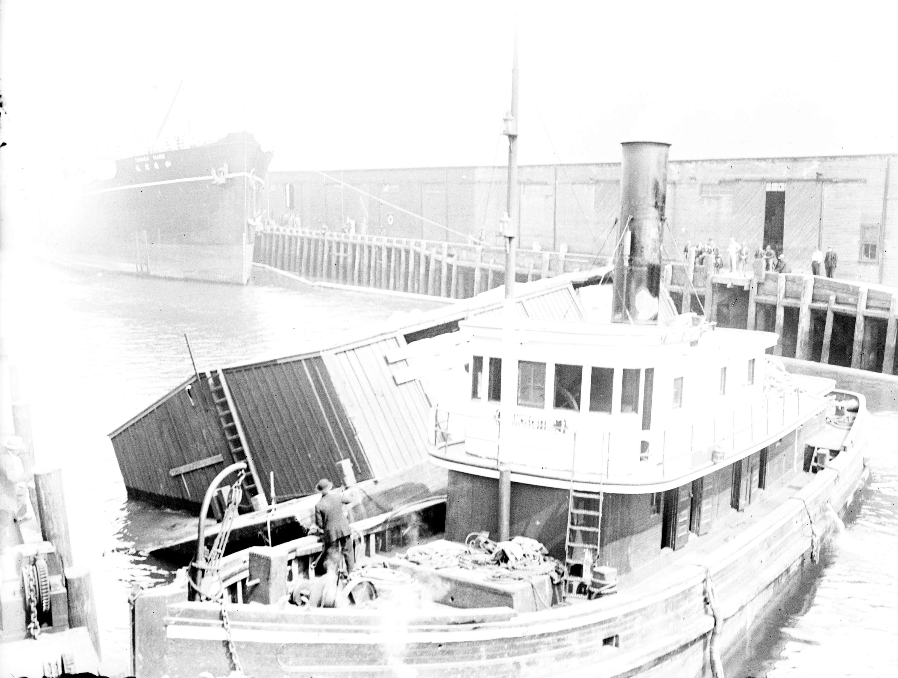 Capsized scow with tug Francis Cutting near dock.jpg