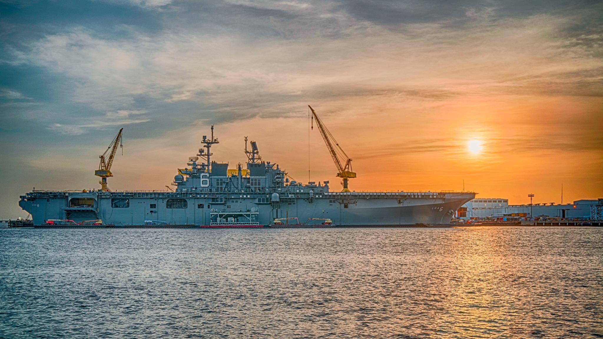 Достраиваемый универсальный десантный корабль USS America (LHA-6) на фоне заката.jpg