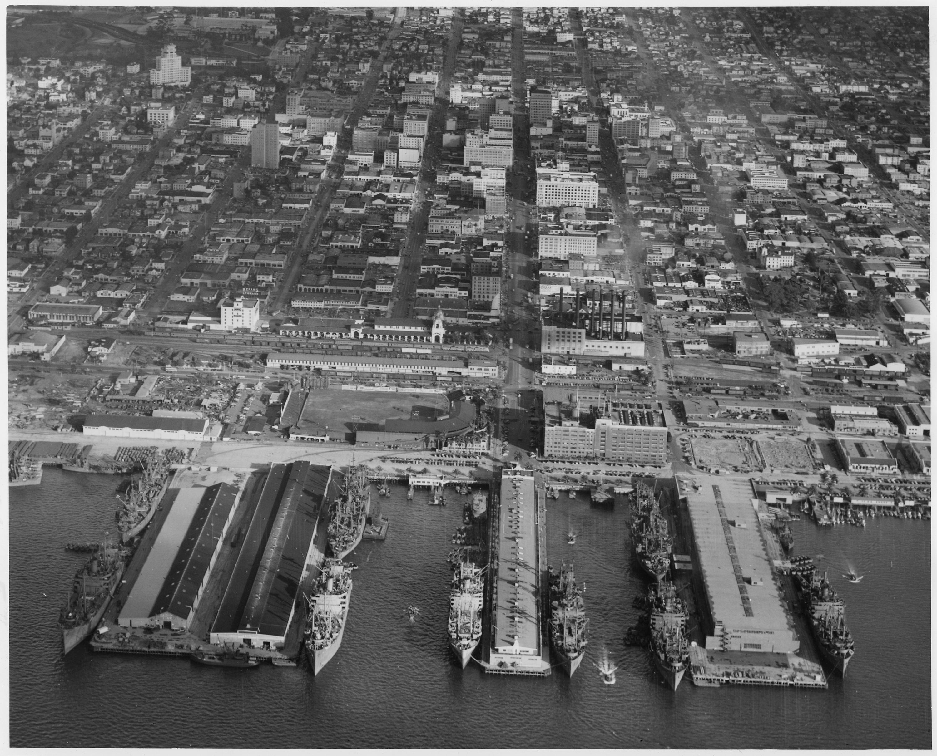 Aerial_photograph_of_piers_at_headquarters_and_at_U._S._Naval_Repair_Base_during_loading_operations_showing_nine..._-_NARA_-_295638.jpg